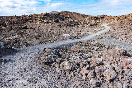Lava field and tourist road trail to vulcano Caldera Blanca, Lanzarote, Canary Islands, Spain.