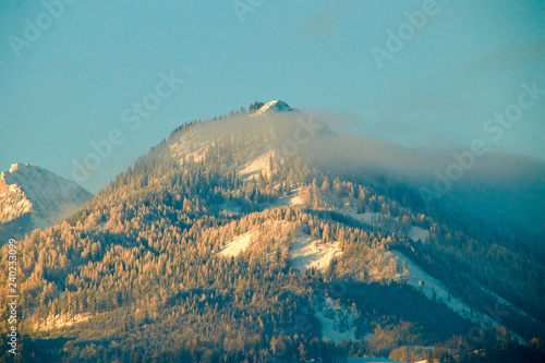 Mountain top in Austria behind fog clouds photo