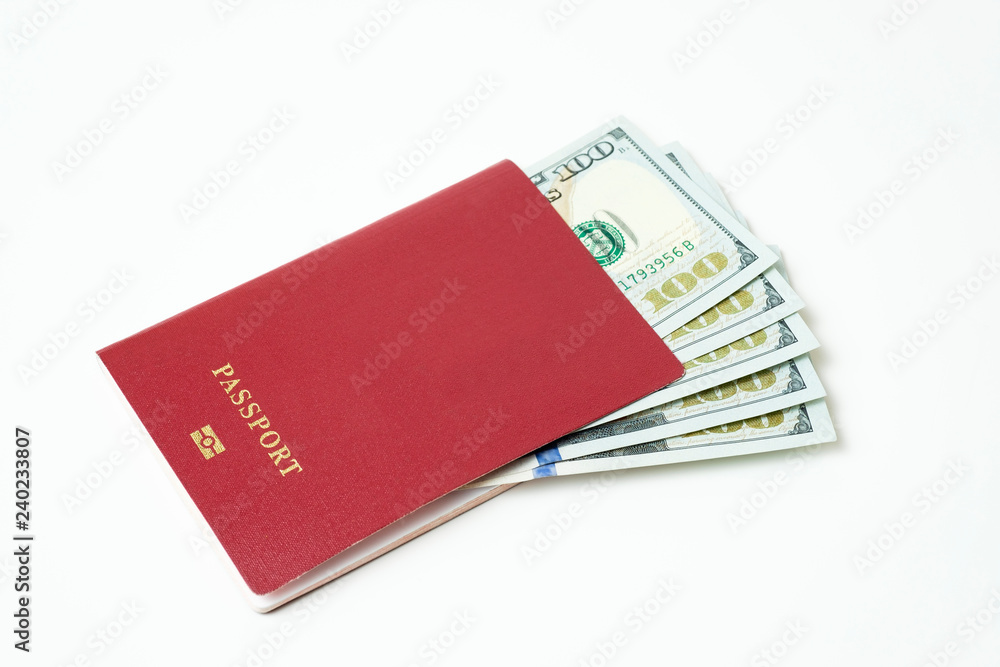Foreign biometric passport with dollars isolated on a white background. Five bills for a hundred dollars. The concept of tourism. The concept of investment. Closeup. Foreign biometric passport with dollars isolated on a white background. Five bills for a hundred dollars. The concept of tourism. The concept of investment. Closeup.