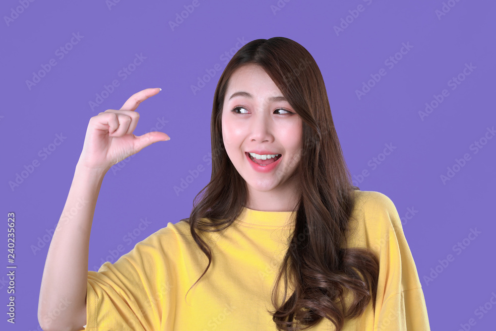 Asian woman recommended vitamin c with hand symbol, yellow t-shirt clothing, purple background Asian woman recommended vitamin c with hand symbol, yellow t-shirt clothing, purple background