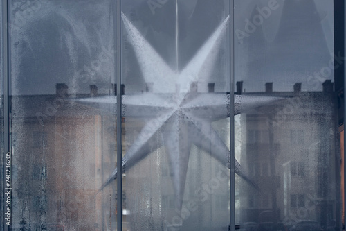 Estrella de navidad tras una ventana en invierno