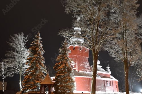 Scenery of wooden church photography  in the night in snowy winter in  Muszynka Poland  photo