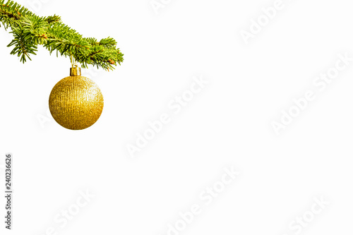 Fir tree branch with a golden glitter ball on white background. Bokeh effects. Christmastime. Christmas postcard. photo