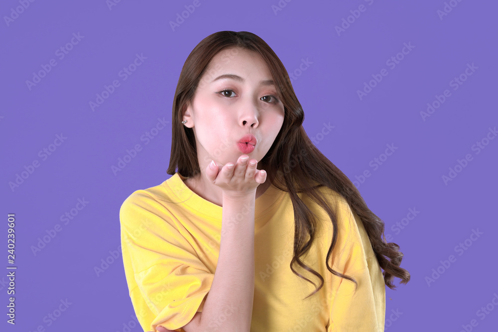Asian woman send kiss, yellow t-shirt clothing, purple background Asian woman send kiss, yellow t-shirt clothing, purple background