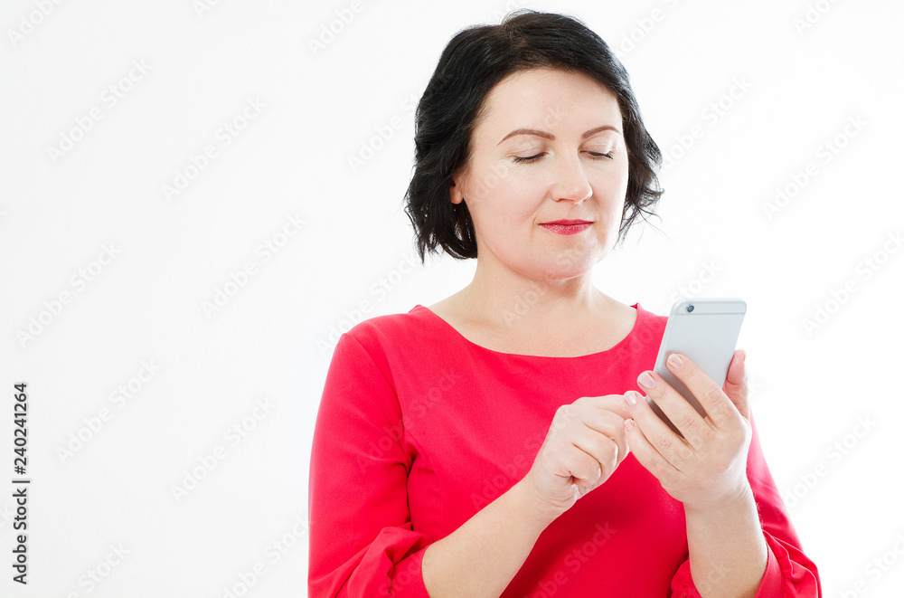 Smiling business woman in red dress having chat text conversation and holding phone Smiling business woman in red dress having chat text conversation and holding phone