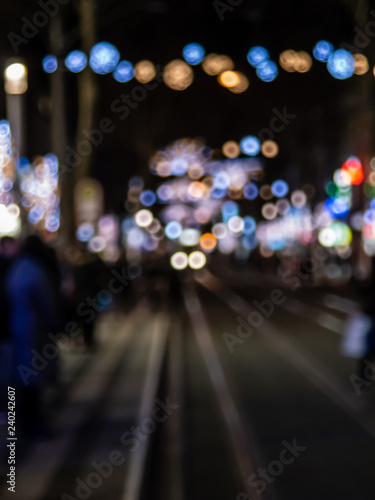 night city life: tram, people and christmas lights blured, bokeh style blured background