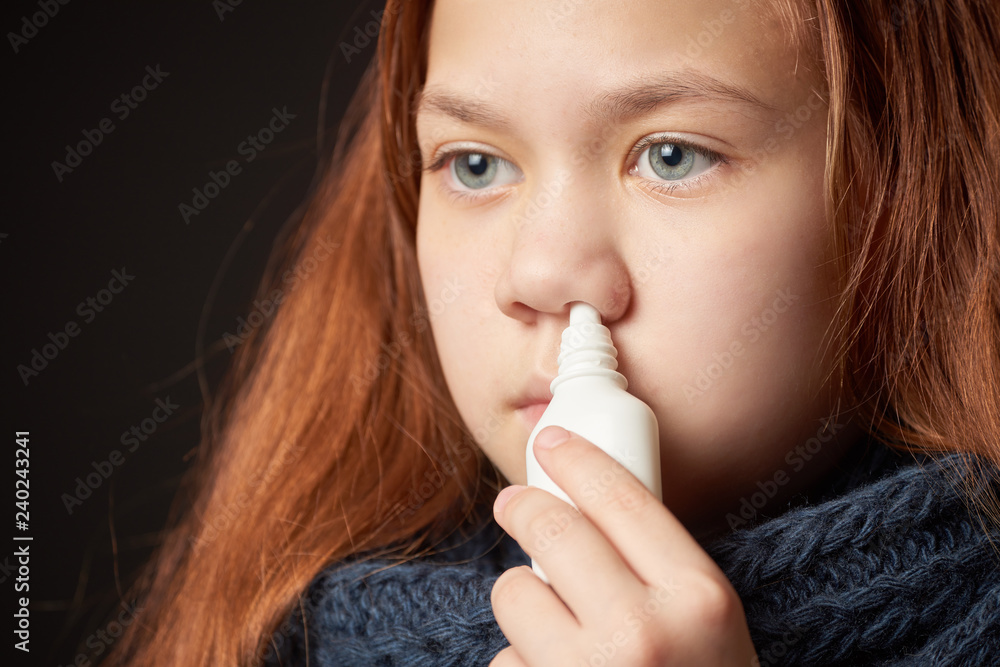 Sick girl with warm scarf around her neck is holding bubble in her hand with drop from runny nose near her nose. Sick girl with warm scarf around her neck is holding bubble in her hand with drop from runny nose near her nose.