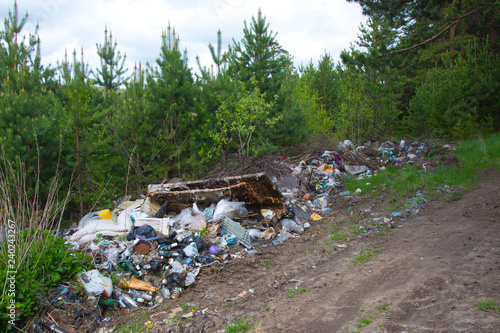 Pollution of the forest by household rubbish. A pile of garbage in the forest. The global problem of pollution.