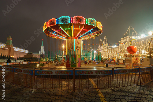 Decorated Red Square in the last days of the 2018 year. Go round carousel gives fun. Central department store (GUM) like bright palace a Kremlin wall as background