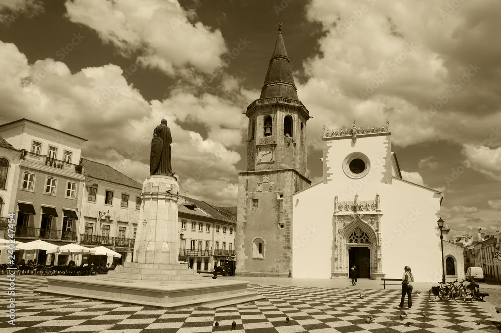 Main square of medieval town Tomar (Portugal). Church of Saint John the Baptist. Tourists. Cafe. Sepia photo.