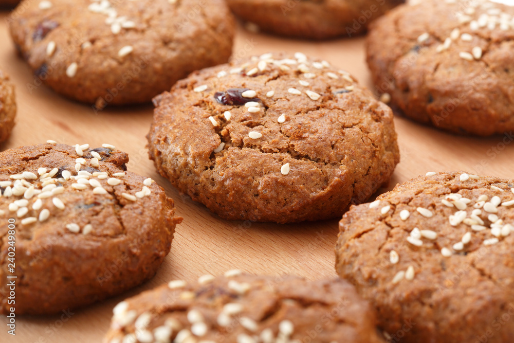 Pattern of oatmeal cookies with dried berries and sesame. Selective focus. Pattern of oatmeal cookies with dried berries and sesame. Selective focus.
