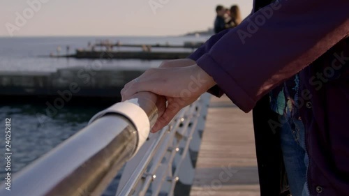 4K Close-up shot of hand touching railing near the sea photo