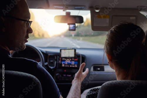 Young European couple is travelling by car, they are discussing the route.