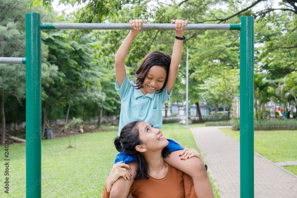 Obraz premium Woman and daughter play with a horizontal bar