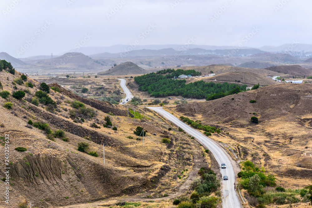 Highway in the steppe among the hills