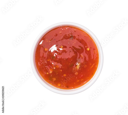 Red hot chilli pepper sauce in ceramic bowl isolated on a white background.Top view