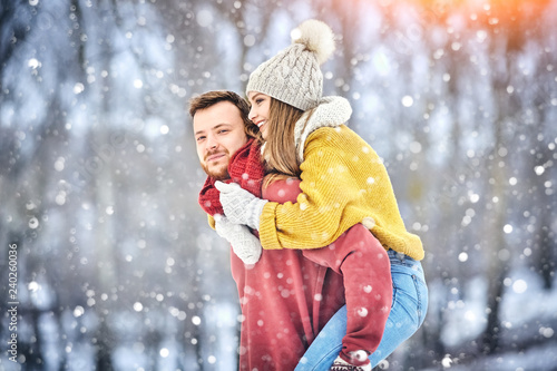 Happy Young Couple in Winter Park laughing and having fun. Family Outdoors.