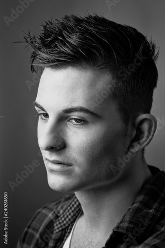 Handsome young man with piercing look and slick haircut. photo