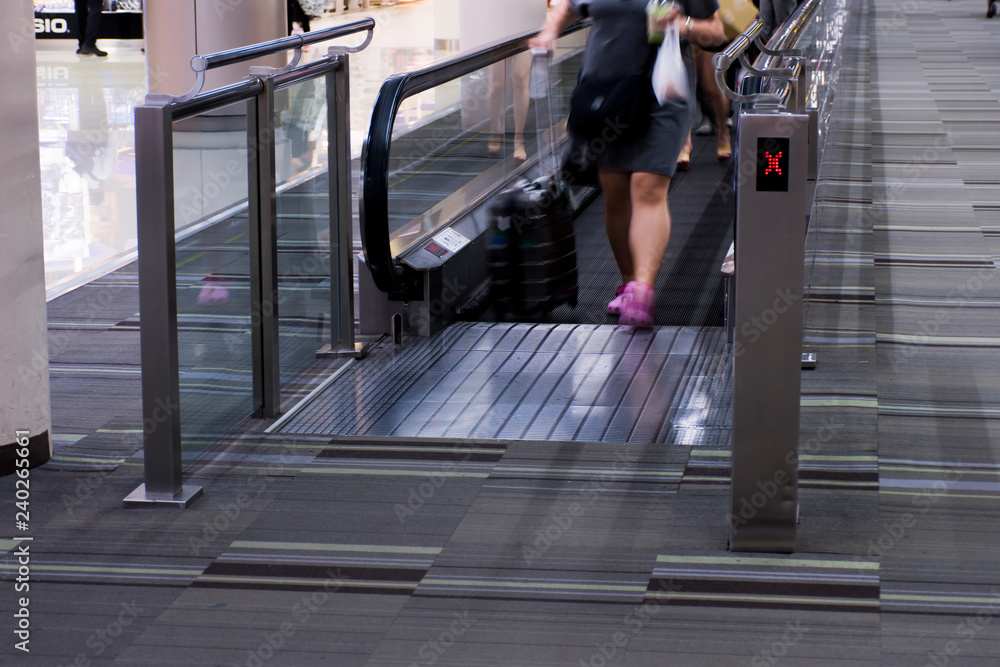 Fototapeta premium People standing on escalators in airports.