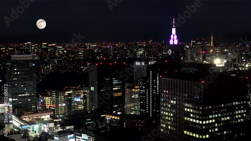 Full moon on the Tokyo skyline  from the Metropolitan Government Building. Shinjuku, Tokyo, Japan photo