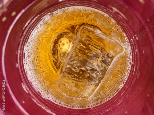 close up on fresh beer with cool ice on red plastice cup. photo