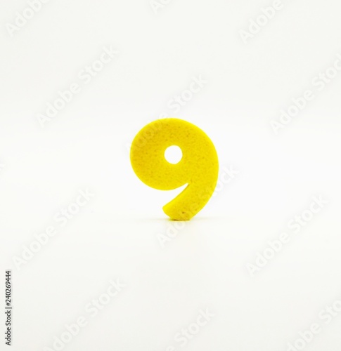 Yellow number nine on white background