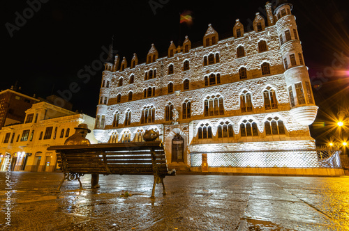 Night view of the building designed by Gaudi in the city of Leon, Botines. You can see a Gaudi sculpture observing the building. Leon, Spain. Winter of 2018.