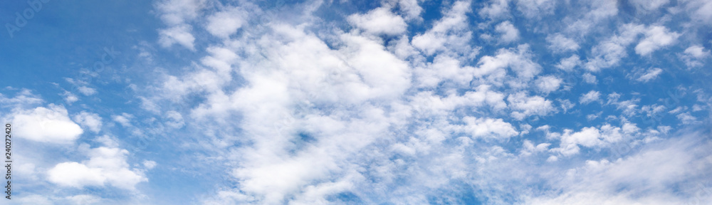 Naklejka premium Cloudscape, blue sky and white fluffy clouds. Natural photo, panoramic view.