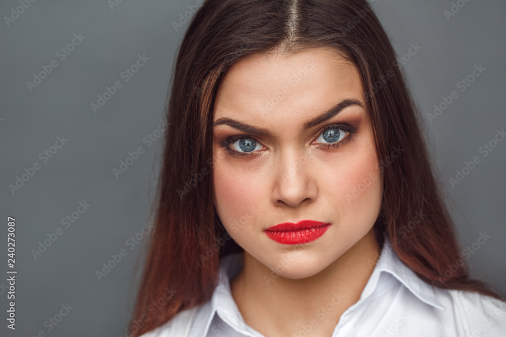 Freestyle. Woman standing isolated on grey looking camera confident close-up Freestyle. Woman standing isolated on grey looking camera confident close-up