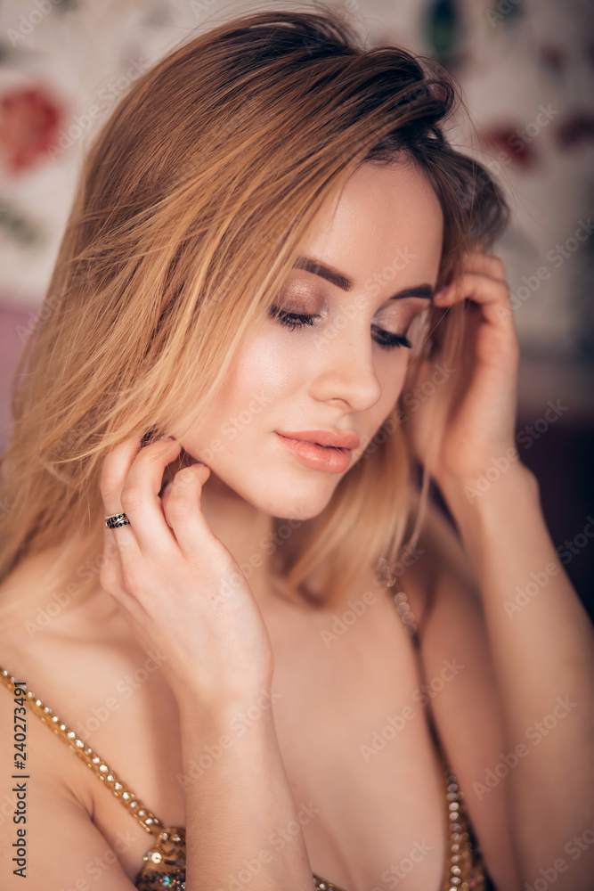 Closeup portrait of sexy blonde woman looking down. Young beautiful girl with professional makeup, clean skin and shiny Golden dress. Fashion, glamour, luxury, party Closeup portrait of sexy blonde woman looking down. Young beautiful girl with professional makeup, clean skin and shiny Golden dress. Fashion, glamour, luxury, party