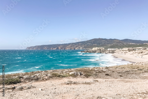 Beautiful coastline with white sand and waves with foam