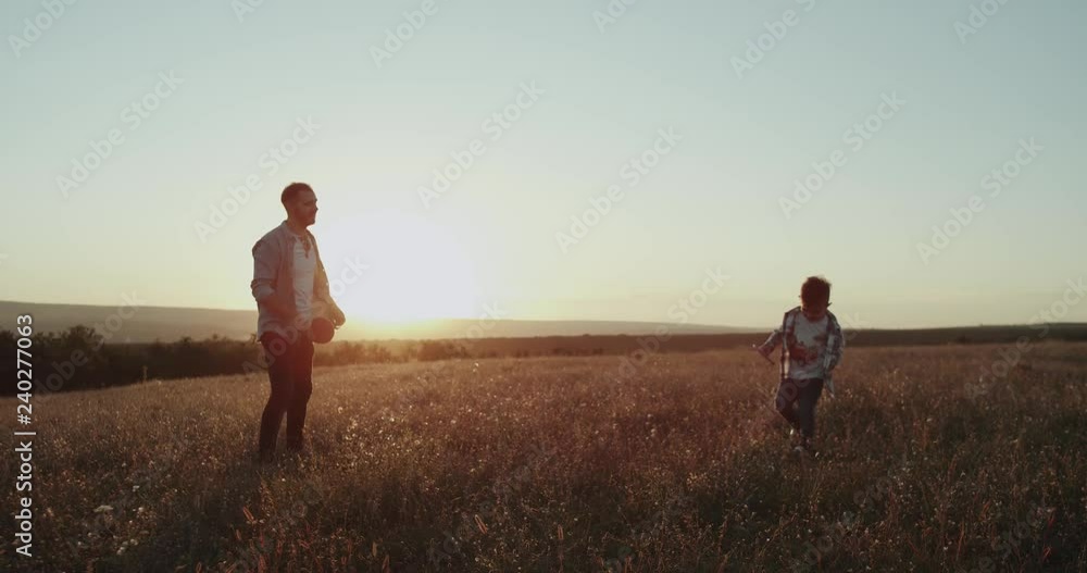 Three years old boy playing funny tennis with his dad at nature , amazing sunset, perfect view. Three years old boy playing funny tennis with his dad at nature , amazing sunset, perfect view.