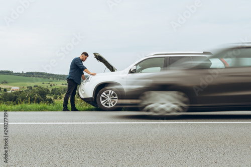 man stand near broken car with opened hood. emergency service