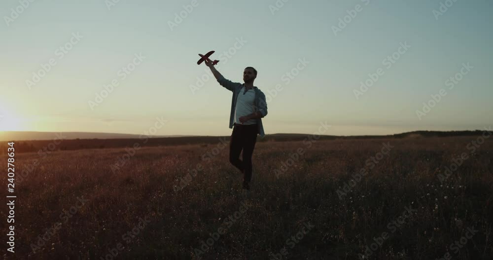 Dreams come true , a young guy playing with a airplane at nature , dreaming to become a pilot , beautiful sunset. Dreams come true , a young guy playing with a airplane at nature , dreaming to become a pilot , beautiful sunset.
