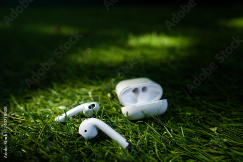 Wireless headphones lie on the grass, close angle
