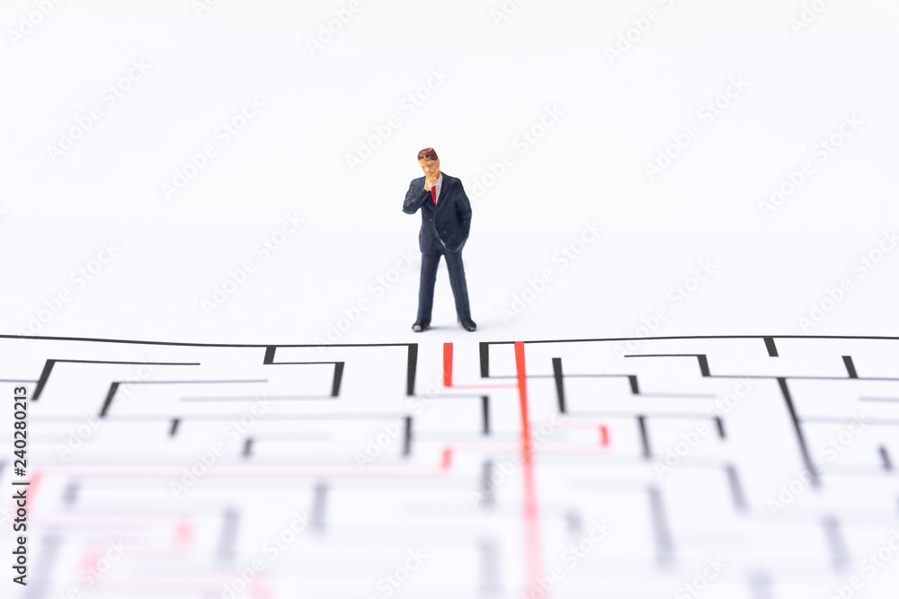 Miniature people, businessman in the labyrinth or maze figuring out the way out. Business concept, finding solution, strategic, and business opportunity. Miniature people, businessman in the labyrinth or maze figuring out the way out. Business concept, finding solution, strategic, and business opportunity.