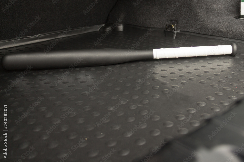 Plastic baseball bat in the luggage compartment of a car, self