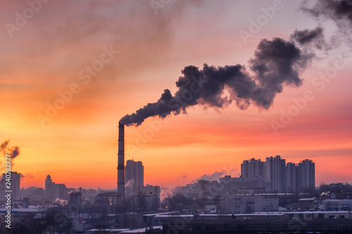 Smoke from an industrial pipe on a frosty sky background © Peter