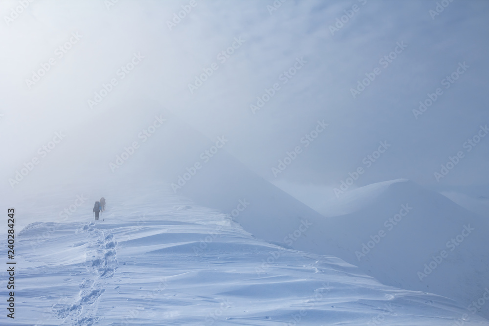 hikers in a winter misty mountain