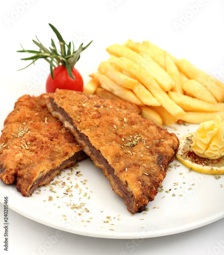 Schnitzel on plate with french fries photo