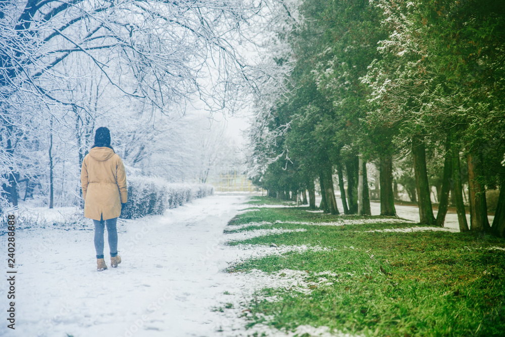 woman walk by park where winter meet spring
