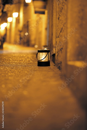 Vintage lantern on a narrow street with soft orange lighting