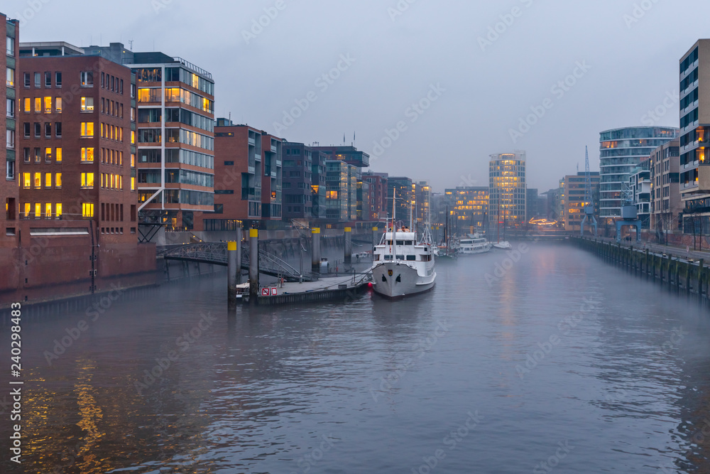 The Harbor District (HafenCity) in Hamburg, Germany, on a foggy day. View of the Sandtorkai and the Kaiserkai across the traditional port (German: Traditionsschiffhafen or Sandtorhafen).