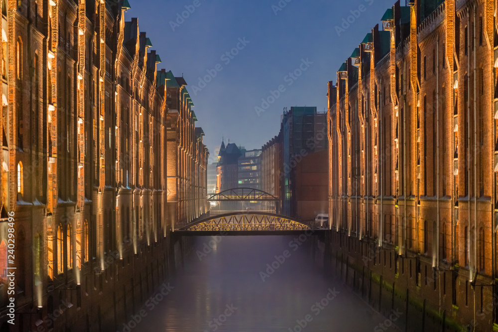 The Warehouse District (Speicherstadt) in Hamburg, Germany, at dusk. View of St. Annenfleet. The largest warehouse district in the world is located in the port of Hamburg within the HafenCity quarter.