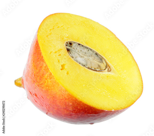 Juicy ripe yellow mango fruit cut in half across isolated on white background