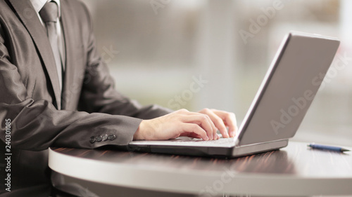 close up.businessman typing on a laptop, sitting at a coffee tab