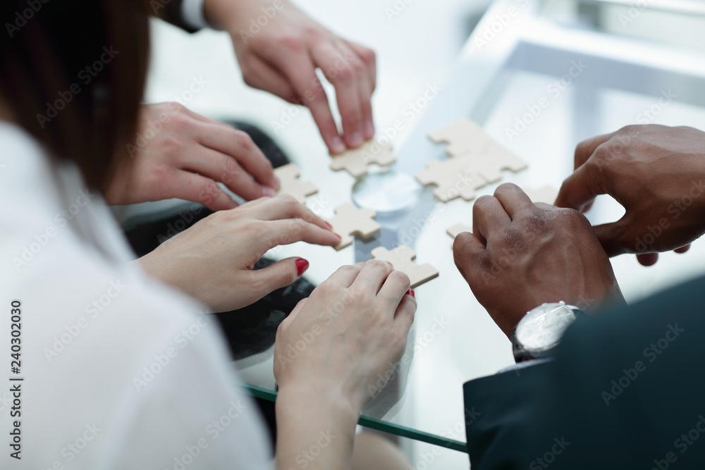 close up. business team assembling puzzle pieces. close up. business team assembling puzzle pieces.