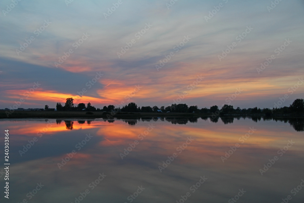 Colorful sky and colorful water in lake reflected in evening. Russia.