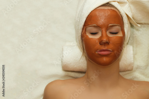 Beautiful happy woman in the spa making face mask treatment.selective focus