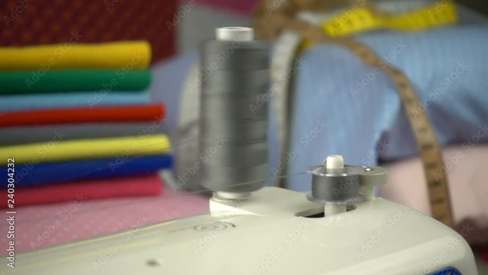Thread is unwound from the reel during sewing to other coil in slow motion. Sewing preparation. Thread is unwound from the reel during sewing to other coil in slow motion. Sewing preparation.